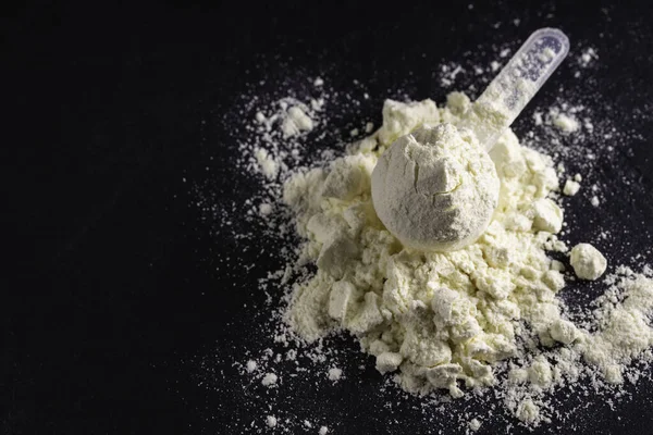 Beyaz protein tozu ve plastik kaşık ölçümü. Spor beslenmesi.