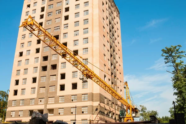 Guindaste e canteiro de obras contra o céu azul — Fotografia de Stock