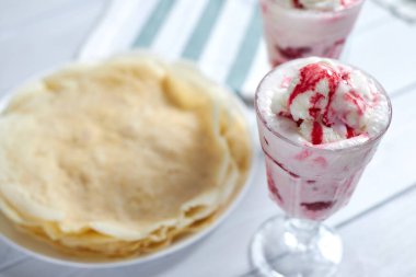 Lezzetli krep yanında ahududu soslu vanilyalı dondurma.