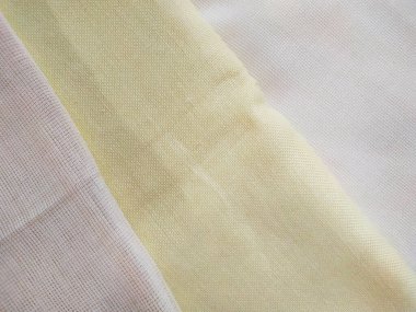 Beyaz, bej ve sarı katlanmış tuval. Parlak kumaş dokusu arkaplanı