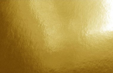 Gölgeler, röfleler ve düz olmayan yüzeyi olan altın folyo dokusu