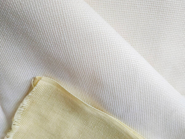 Pale yellow and milk white folded canvas. Fabric texture background