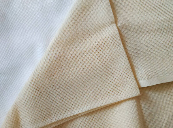 Beige and milk white folded canvas. Fabric texture 