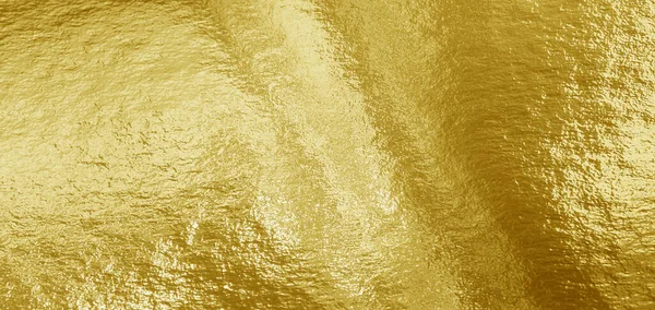 Gold foil background with highlights and uneven texture