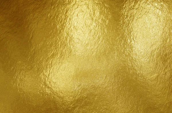 Gold foil texture background with highlights and uneven surface