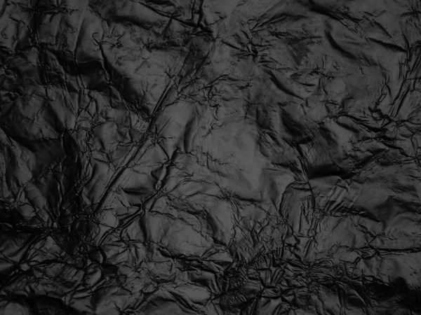 Wrinkled black foil texture background