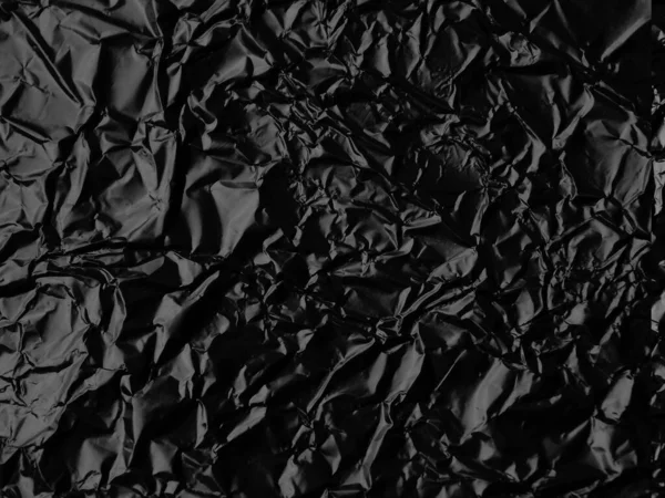 Wrinkled black foil texture background