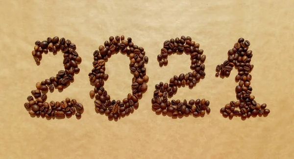 Logo 2021 of coffee beans on a brown craft paper background. Happy New 2021 Year