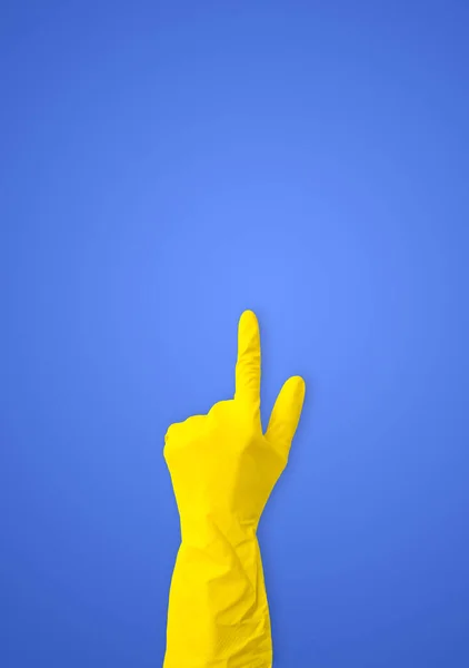 Hand Yellow Rubber Gloves Points Blue Background Copy Space — Stock Photo, Image