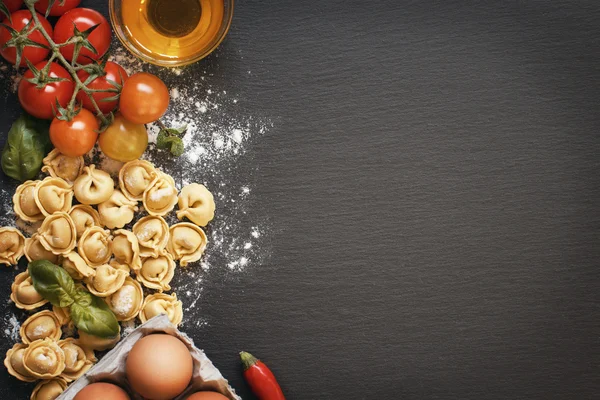Massa de tortellini fresca e ingredientes em uma placa escura — Fotografia de Stock