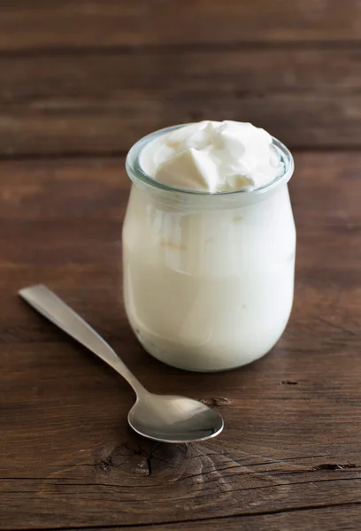 Jar of fresh greek yogurt and spoon — Stock Photo, Image