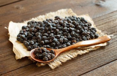 Ahşap bir masa üzerinde bir kaşıkla siyah nohut 