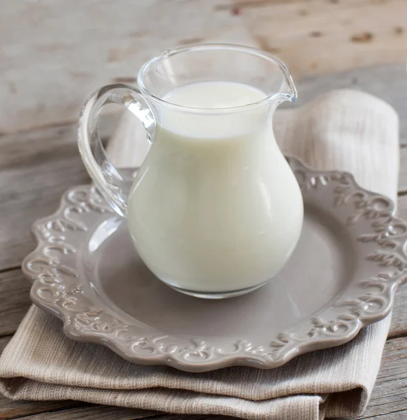 Молоко в банке на деревянном столе — стоковое фото