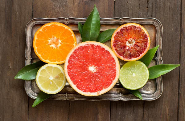 Fresh citrus fruits with leaves on a  wooden table — Stock Photo, Image