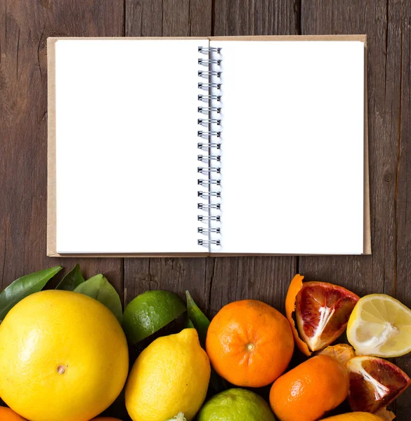 Fresh citrus fruits with cnotebook — Stock Photo, Image