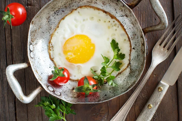 Smažená vejce s rajčaty a bylinkami n stará pánev — Stock fotografie