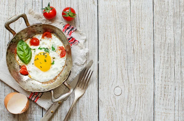 Fried jaj z pomidorami i ziołami n starego patelni — Zdjęcie stockowe