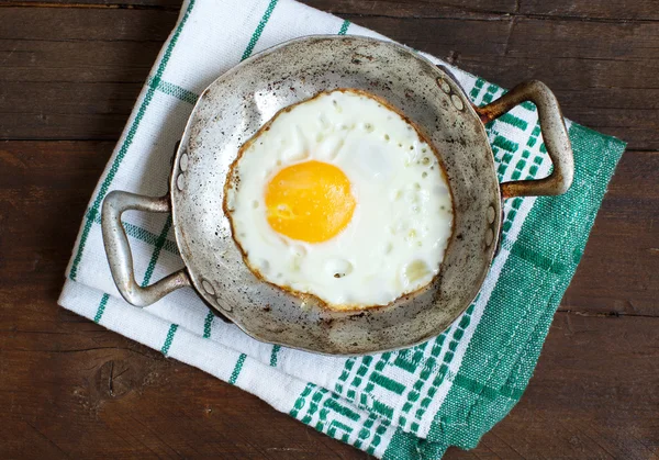 Жареное яйцо в старой сковородке на салфетке — стоковое фото