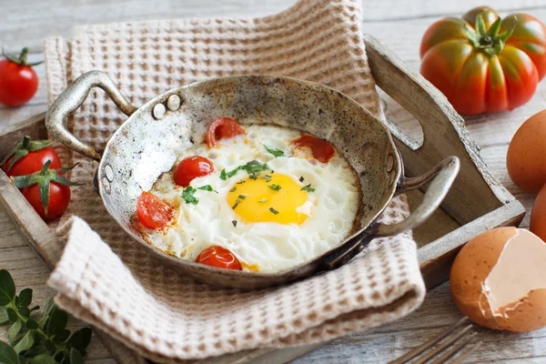 Fried jaj z pomidorami i ziołami n starego patelni — Zdjęcie stockowe