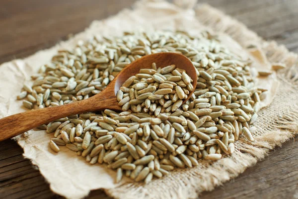 Pila de grano de centeno crudo seco con una cuchara — Foto de Stock