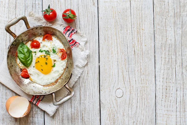 Fried jaj z pomidorami i ziołami n starego patelni — Zdjęcie stockowe