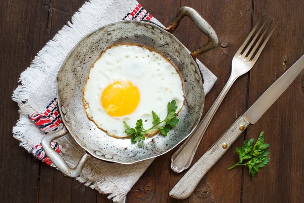 Жареное яйцо с травами на старой сковороде — стоковое фото