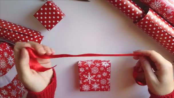 Mujer ata un lazo de cinta y envuelve regalos — Vídeo de stock