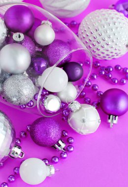 Mor arka planda şarap kadehinde Noel mücevherleri. Yakın plan.