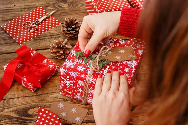 Vrouw Wikkelt Een Kerstcadeau Een Houten Tafel Close — Stockfoto