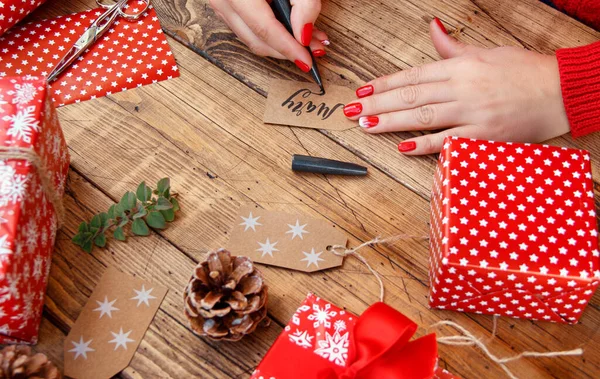 Handen Schrijven Naam Cadeau Tag Voor Kerstcadeau Een Houten Tafel — Stockfoto