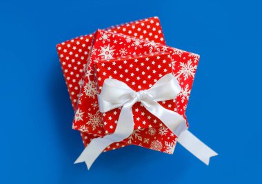 Kırmızı desenli Noel hediyesi kutuları mavi üst manzarada izole edilmiş.