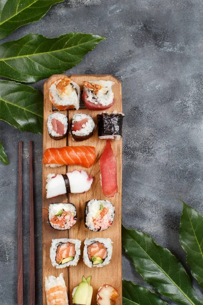 Sushi设置黑鬼和寿司滚动在木制托盘顶部视图与复制空间 — 图库照片