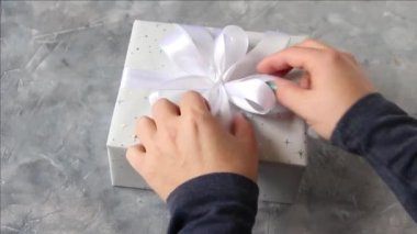 Eller masanın üzerindeki hediyeyi çözer.