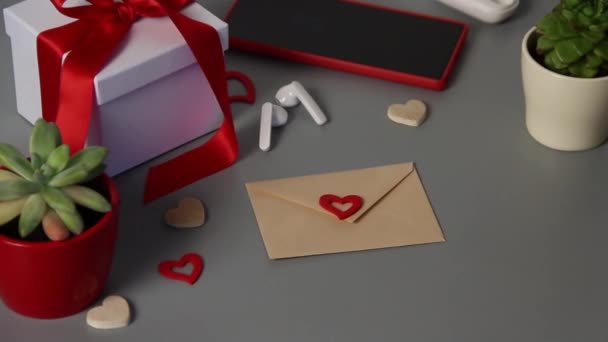 Невеликий конверт з серцем біля подарунка на день Святого Валентина — стокове відео