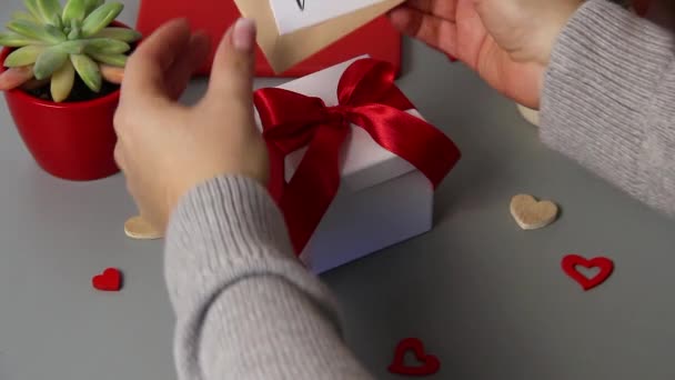 Niech ktoś rozwiąże łuk na walentynkowym prezencie z wiadomością Bądź moją VALENTINE — Wideo stockowe