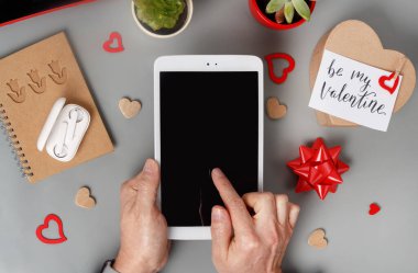 Sevgililer Günü hediyesi olarak tablet kullanan eller ve gri masadaki benim VALENTINE kart üst görüntüm ol