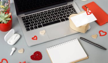 Modern aletlerle Sevgililer Günü konsepti. Gri masada mevcut ve boş kart. Yakın plan.