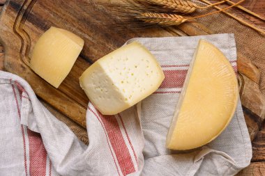 Tahta bir masanın üstünde taze ev yapımı İtalyan peyniri parçaları.