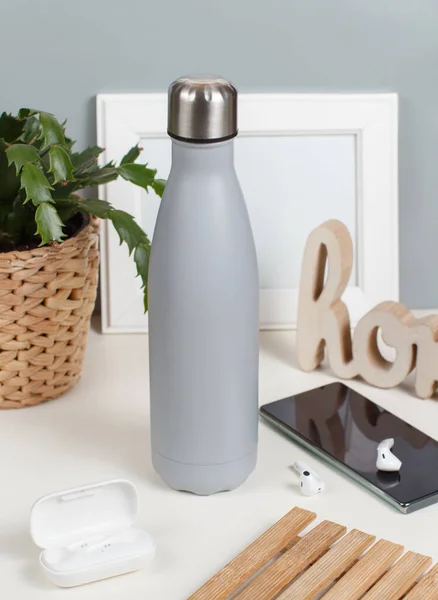 Graue Isolierte Flasche Auf Weißem Schreibtisch Umgeben Von Modernen Gadgets — Stockfoto
