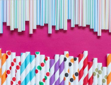 Pembe arka plan görünümünde plastik pipetler yerine modern yeniden kullanılabilir kağıt içme pipetleri