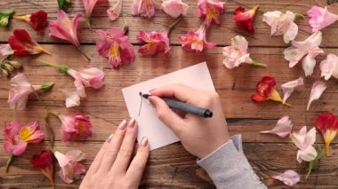 Çiçeklere yakın bir karta ilkbahar yazılıyor 