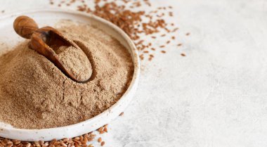 Çiğ keten tohumu unu seramik bir tabakta yakın çekimde.