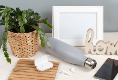 Beyaz masadaki gri yalıtımlı şişe modern cihazlarla çevrili.