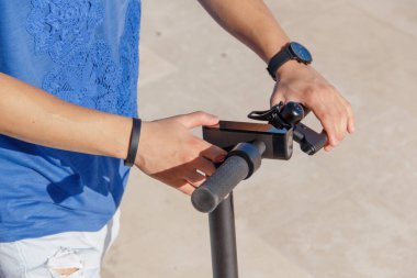 Genç adam elektrikli scooter 'ı çalıştırıyor.