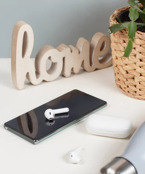 Teléfono Celular Auriculares Inalámbricos Botella Planta Una Mesa Cerca — Foto de Stock