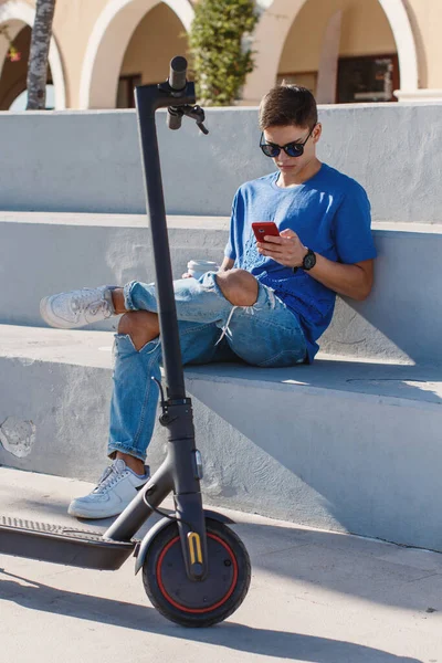 Young Caucasian Man Sitting Outdoor Electric Scooter Using Smart Phone — Stock Photo, Image