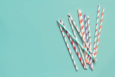 Çizgili ve noktalı kağıt yeşil arka planda pipet içiyor. Çevre dostu ve geri dönüşümlü.