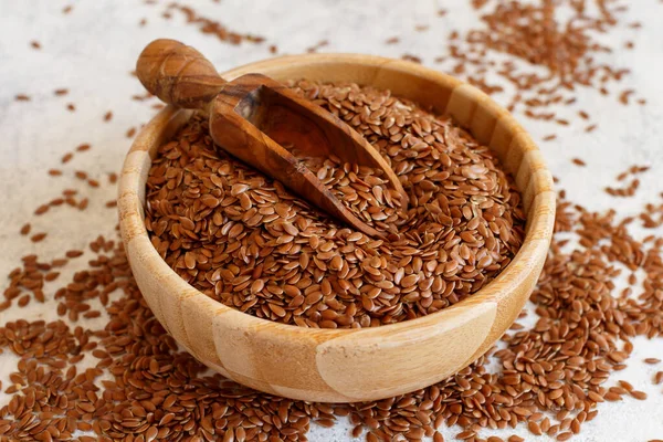 Tahta bir kasede kaşık içinde çiğ keten tohumu. 