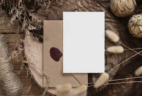 Prázdná Papírová Karta Obálka Tmavém Dřevěném Stole Zaschlými Rostlinami Kolem — Stock fotografie