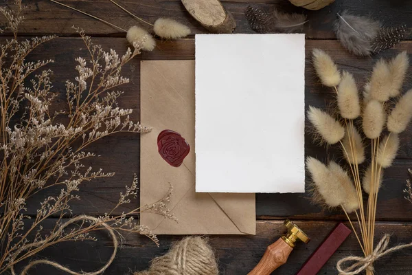 Tarjeta Papel Blanco Sobre Sellado Mesa Madera Con Plantas Secas —  Fotos de Stock